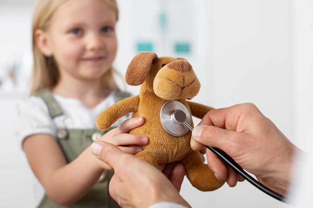 niña con oso de peluche en el doc