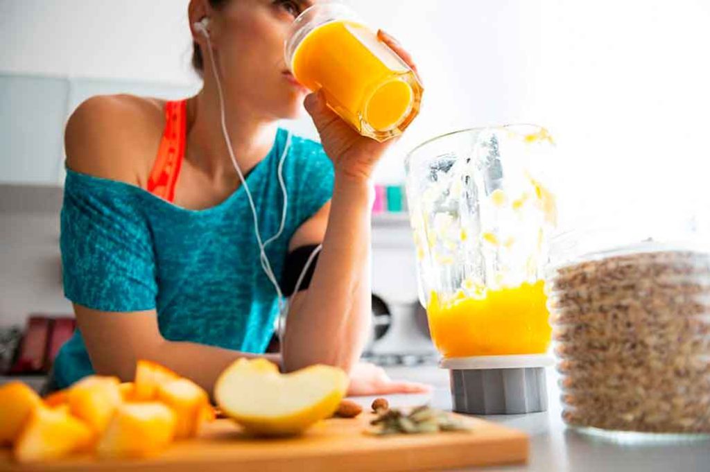 mujer tomando jugo de naranja