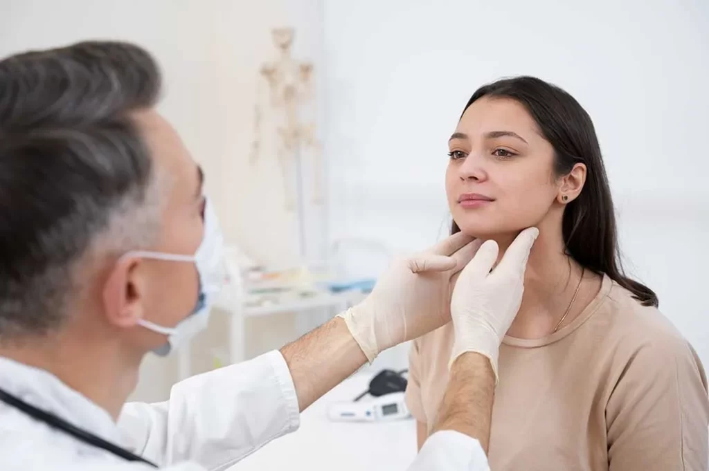 doctor revisando tiroides de mujer